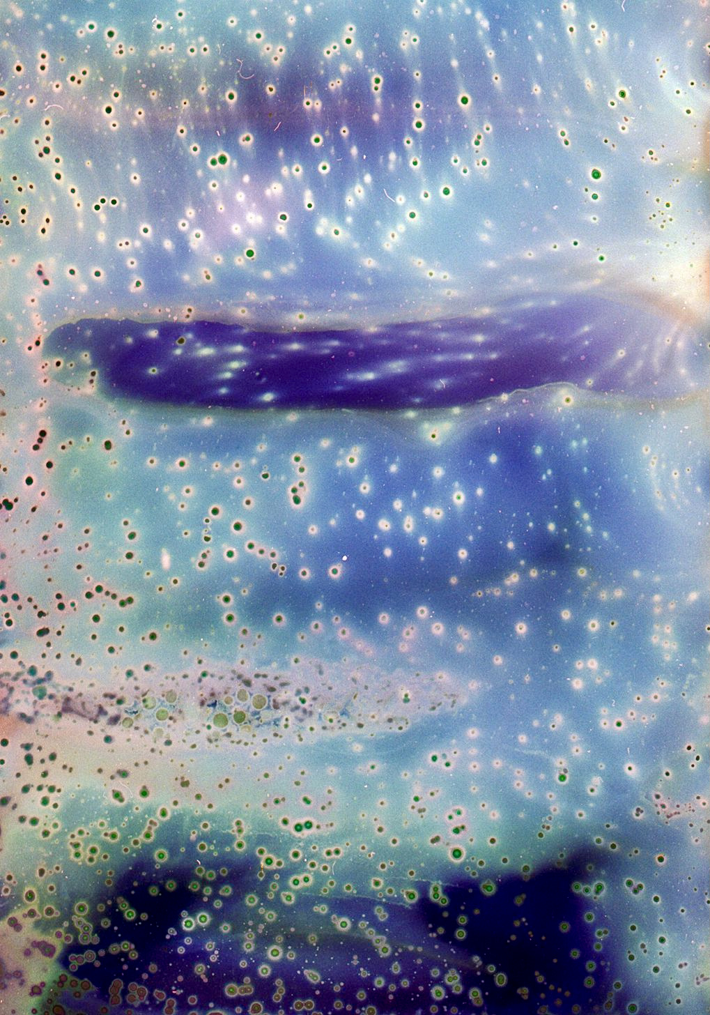 Bearbeitete Farbnegative mit zerlaufenen gepunkteten Formen. Sie erinnern an eine Galaxie und Sterne