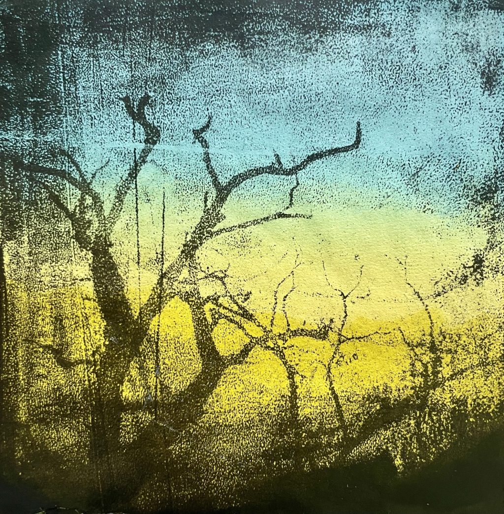 Ein Gelli-Print mit einem schwarzen kahlen Baum und im Hintergrund gelb-blaue Farbtöne.